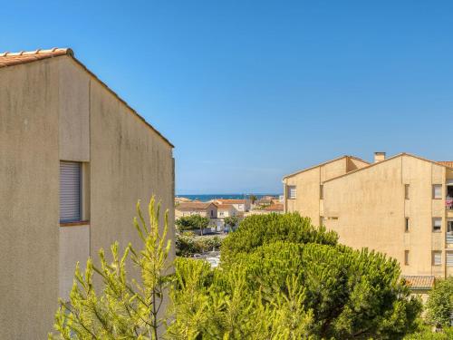 a building and trees in front of a building at Apartment Les Pins by Interhome in Narbonne-Plage