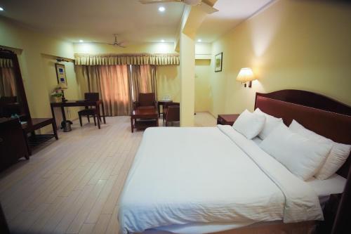 um quarto de hotel com uma cama e uma sala de estar em The Central Park Hotel em Gwalior