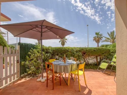 - une table et des chaises sous un parasol sur la terrasse dans l'établissement Apartment Les Vagues by Interhome, à Saint-Cyr-sur-Mer