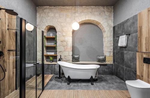 a bathroom with a bath tub and a sink at Old City Boutique - בוטיק העתיקה מבית רשת מלונות לה פינקה in Beer Sheva