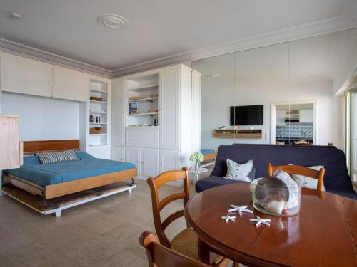 un salon avec un canapé bleu et une table dans l'établissement Apartment le corail by Interhome, à Villeneuve-Loubet