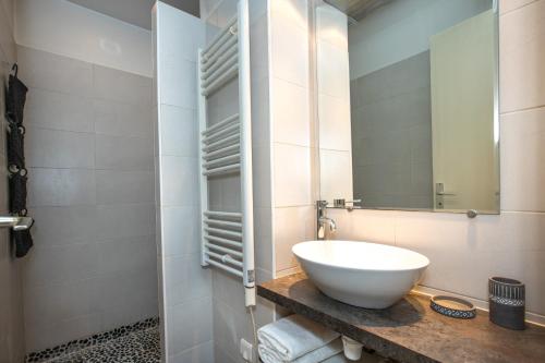 een badkamer met een witte wastafel en een spiegel bij Spacieux appartement de 70 m2, 2 chambres, au calme proche du Vieil Antibes in Antibes