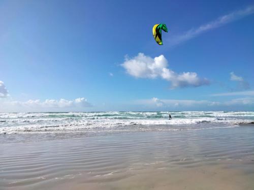 a person is flying a kite on the beach at Holiday Home Pointe du Raz by Interhome in Plovan