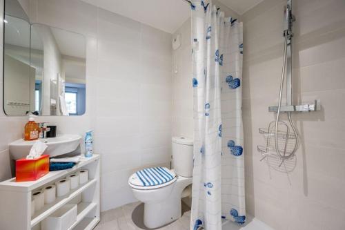 une salle de bain blanche avec toilettes et douche dans l'établissement Juan Les Pins Two Bed Apt Beach Access, à Antibes