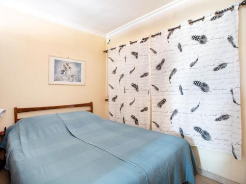 - une chambre avec un lit bleu et un mur orné d'oiseaux dans l'établissement Studio Le Tiercé by Interhome, à Cagnes-sur-Mer