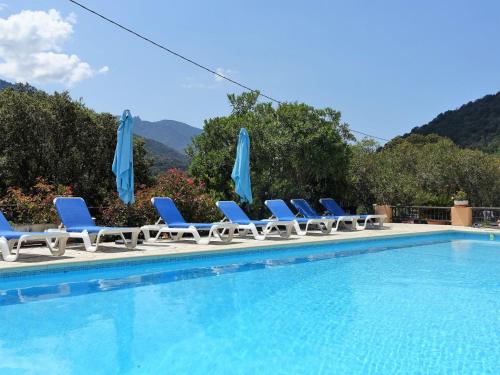 un gruppo di sedie e ombrelloni accanto alla piscina di Studio Cabannaccia-4 by Interhome a Serriera