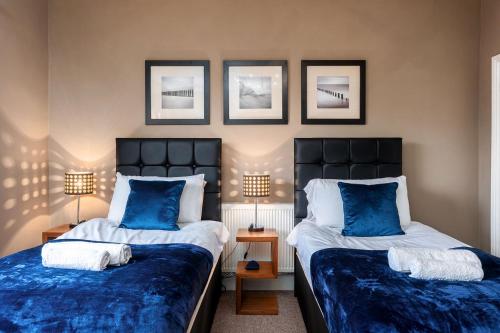 two beds in a room with blue and white at Free Parking Stylish House Near Humber Bridge in Barton-upon-Humber