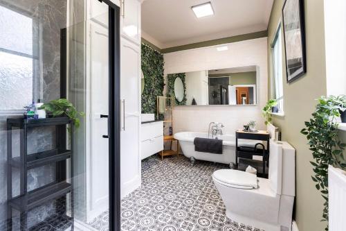 a bathroom with a tub and a toilet and a sink at Free Parking Stylish House Near Humber Bridge in Barton-upon-Humber