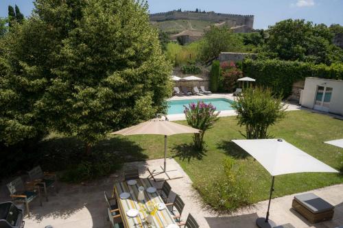a pool with chairs and umbrellas in a yard at Unique Villa in Famous Provence Historic Village in Villeneuve-lès-Avignon