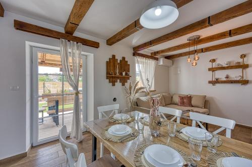 a dining room with a table and chairs and a window at Casa Darel with Whirlpool in Vižinada