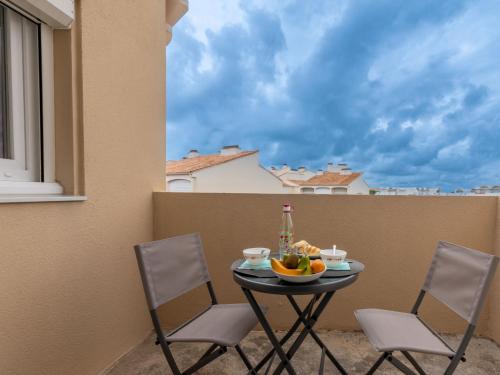 - une table avec des chaises et une corbeille de fruits sur le balcon dans l'établissement Apartment Les Sables d'Or-12 by Interhome, au Grau-du-Roi