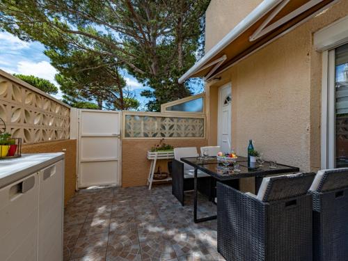 un patio avec une table et des chaises et une clôture dans l'établissement Apartment Les Cabestans 1-2-3-5 by Interhome, au Barcarès