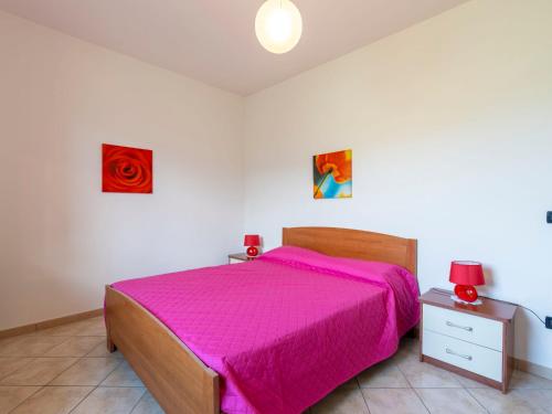 a bedroom with a bed with a pink bedspread at Apartment Ulivo by Interhome in Gazzelli