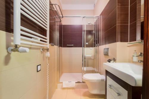 a bathroom with a shower and a toilet and a sink at Villa Baltic Dream in Międzyzdroje