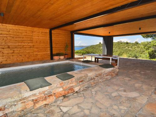 a swimming pool in a house with a wooden ceiling at Holiday Home Villa Baraka by Interhome in Božava