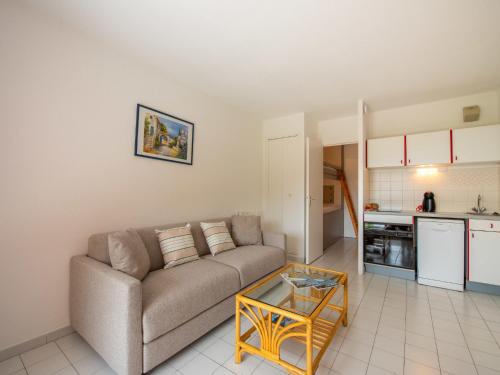 un salon avec un canapé et une table dans l'établissement Studio Le Hameau du Soleil-4 by Interhome, à Cavalaire-sur-Mer