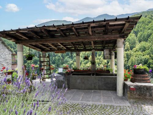 a wooden pergola with flowers in a garden at Chalet Il Gianlupo Grigio by Interhome in Bognanco