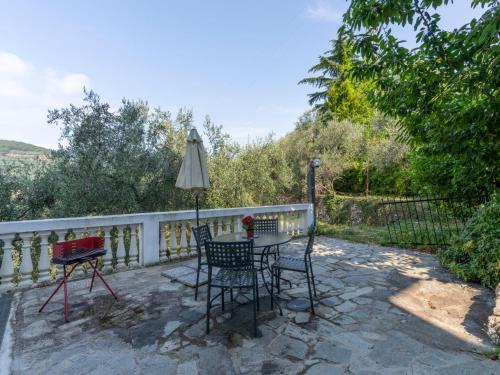 a patio with a table and chairs and an umbrella at Holiday Home Agriturismo U Rundu by Interhome in Gazzelli