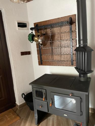 a stove in a kitchen next to a wall at Бутикова къща за гости Елена село Кипилово in Kipilovo