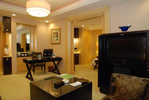 a living room with a large television and a table at 东莞君兰酒店 Grand land hotel in Dongguan