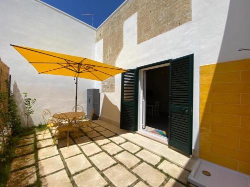 d'une terrasse avec une table et un parasol jaune. dans l'établissement Apartment Spicchi di Salento-1 by Interhome, à Vernole