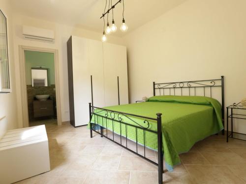 a bedroom with a green bed and a bathroom at Apartment Spicchi di Salento-3 by Interhome in Vernole