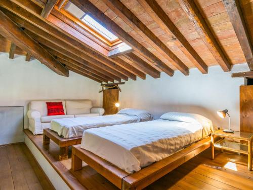 two beds in a room with wooden ceilings at Holiday Home Marte by Interhome in Pereta
