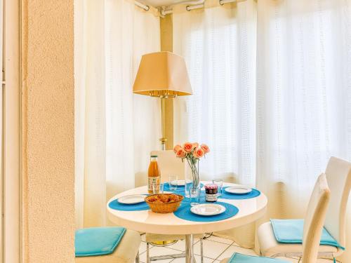 une table blanche avec un vase de fleurs sur elle dans l'établissement Apartment La Palme d'Or-18 by Interhome, au Cap d'Agde