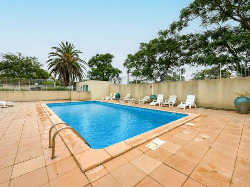une piscine avec des chaises longues et une clôture dans l'établissement Apartment La Palme d'Or-18 by Interhome, au Cap d'Agde