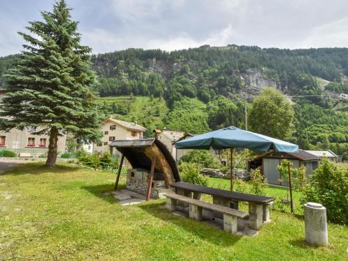 a park with a bench and an umbrella at Apartment Isola di Madesimo Apartments-1 by Interhome in Isola