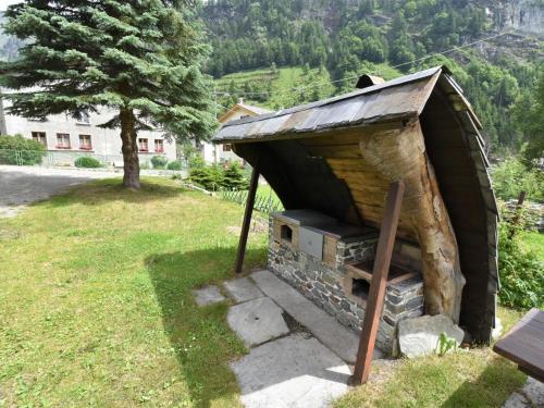 a small wood fired oven in a grass field at Apartment Isola di Madesimo Apartments-1 by Interhome in Isola