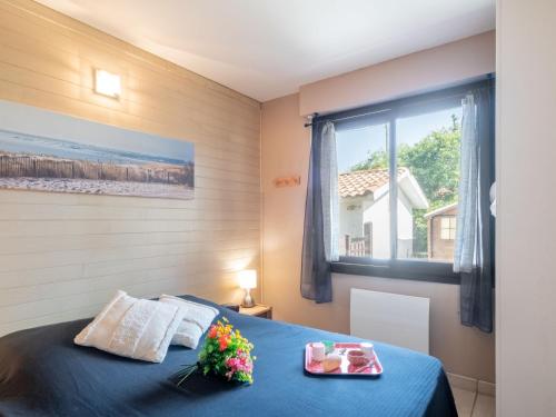 une chambre avec un lit bleu et une fenêtre dans l'établissement Apartment Palombe by Interhome, à Mimizan