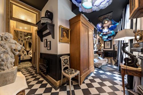 a living room with a fireplace and a checkered floor at Les Petites Suites Dieppoises - La Demeure de Peau d'Ane in Dieppe