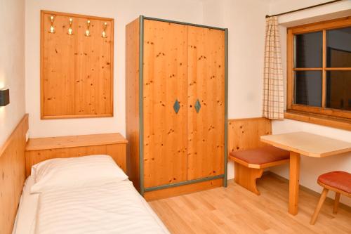 a bedroom with a bed and a desk and a table at Appartements neben der Gondelbahn - Haus Süd in Brixen im Thale