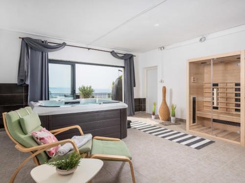 a living room with a tub and chairs at Holiday Home Villa sunset view by Interhome in Senj