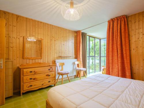 a bedroom with a bed and a dresser and a window at Apartment Appartamento Antermoia by Interhome in Mazzin