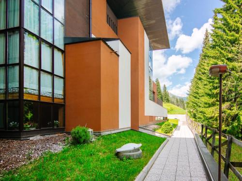 a building with a grassy yard next to a building at Apartment Appartamento Antermoia by Interhome in Mazzin