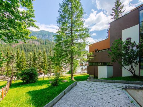 an exterior view of a building with a lawn and trees at Apartment Appartamento Antermoia by Interhome in Mazzin