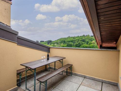 d'un balcon avec une table et des bancs. dans l'établissement Apartment Azalea by Interhome, à Lucino