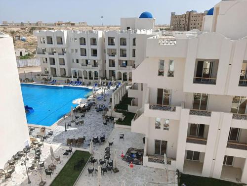 uma vista aérea de um hotel com uma piscina em شاليه الزمردة بمنتجع سانتوريني em El Alamein