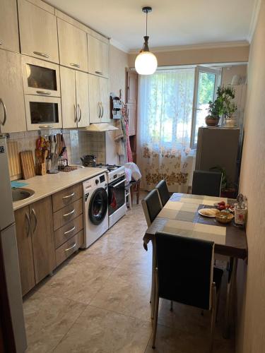 une cuisine avec une table et des chaises ainsi qu'une salle à manger dans l'établissement Apartment Erekle, à Bordjomi