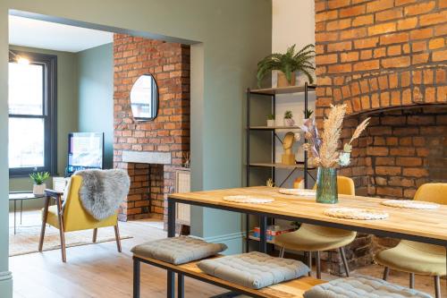 a dining room with a table and a brick wall at Stunning Scandi Abode in Manchester Parking in Manchester