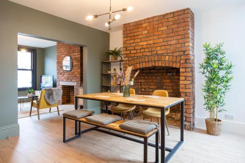 a dining room with a brick fireplace and a table and chairs at Stunning Scandi Abode in Manchester Parking in Manchester
