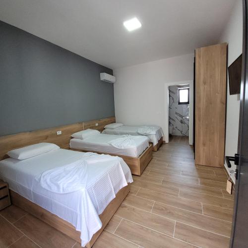 a hotel room with three beds and a hallway at Hotel Erandi in Rinas