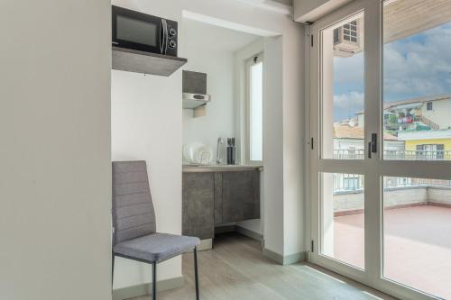 a living room with a chair and a balcony at Residence Velò - Bike & Family in Giulianova