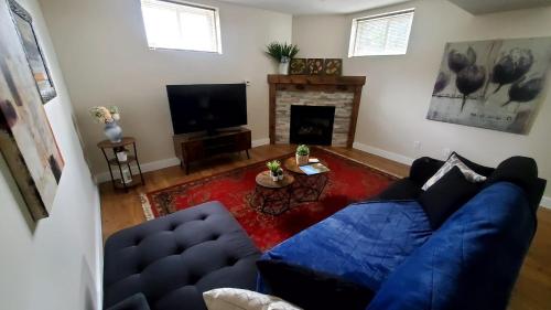 a living room with a blue couch and a fireplace at Spacious Guest Suite in Hamilton