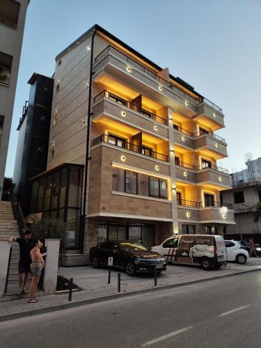 a large building with cars parked in front of it at AMD Premium rooms Budva in Budva