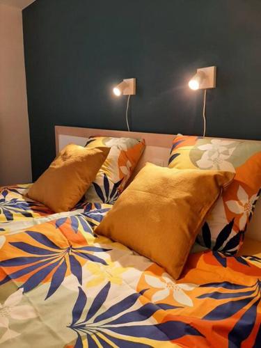 a bed with two pillows and two lamps on it at Au Grand Pierrot in Spa