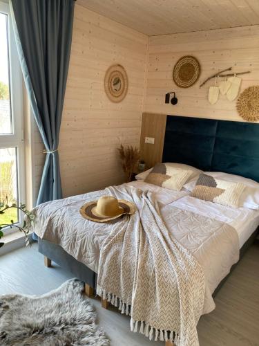 sypialnia z łóżkiem z kapeluszem w obiekcie Domki Morska Przygoda w Sarbinowie