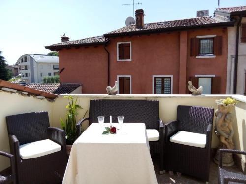 a table and chairs on the balcony of a house at B&B Gardasee in Castelnuovo del Garda